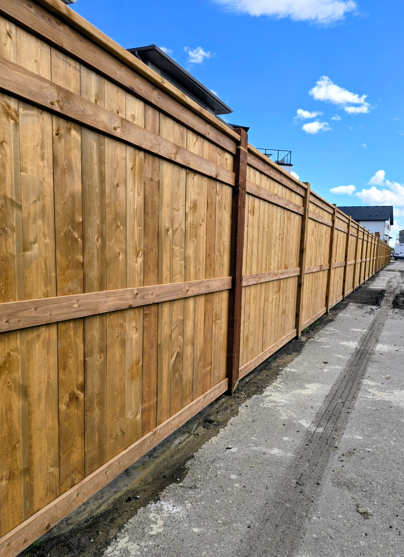Long cedar fence run along a back lane