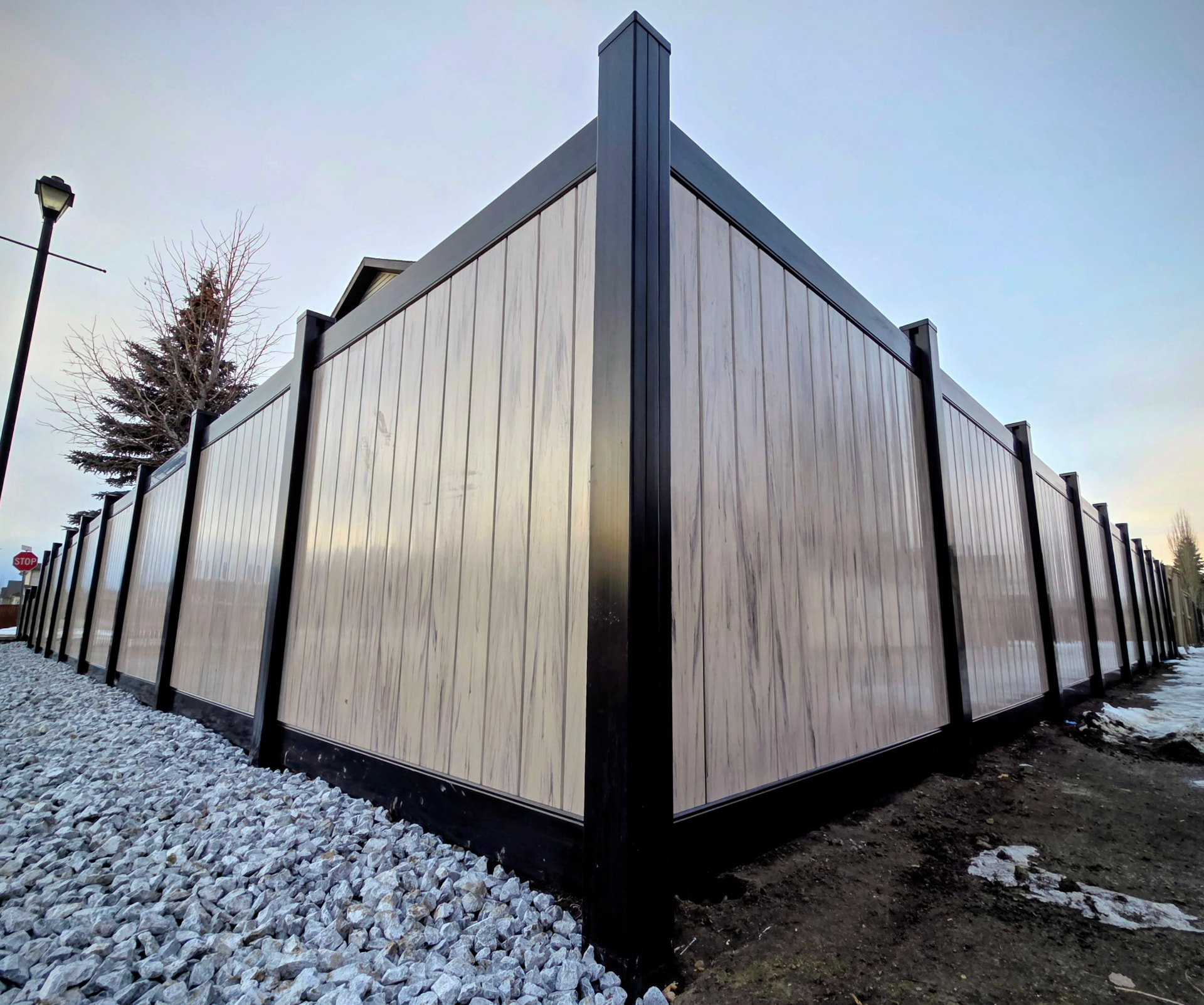 Black-post vinyl privacy fence along a residential sidewalk