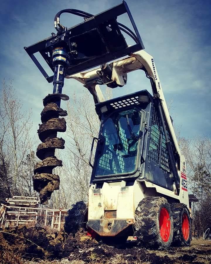 Bobcat skid steer with auger attachment drilling post holes