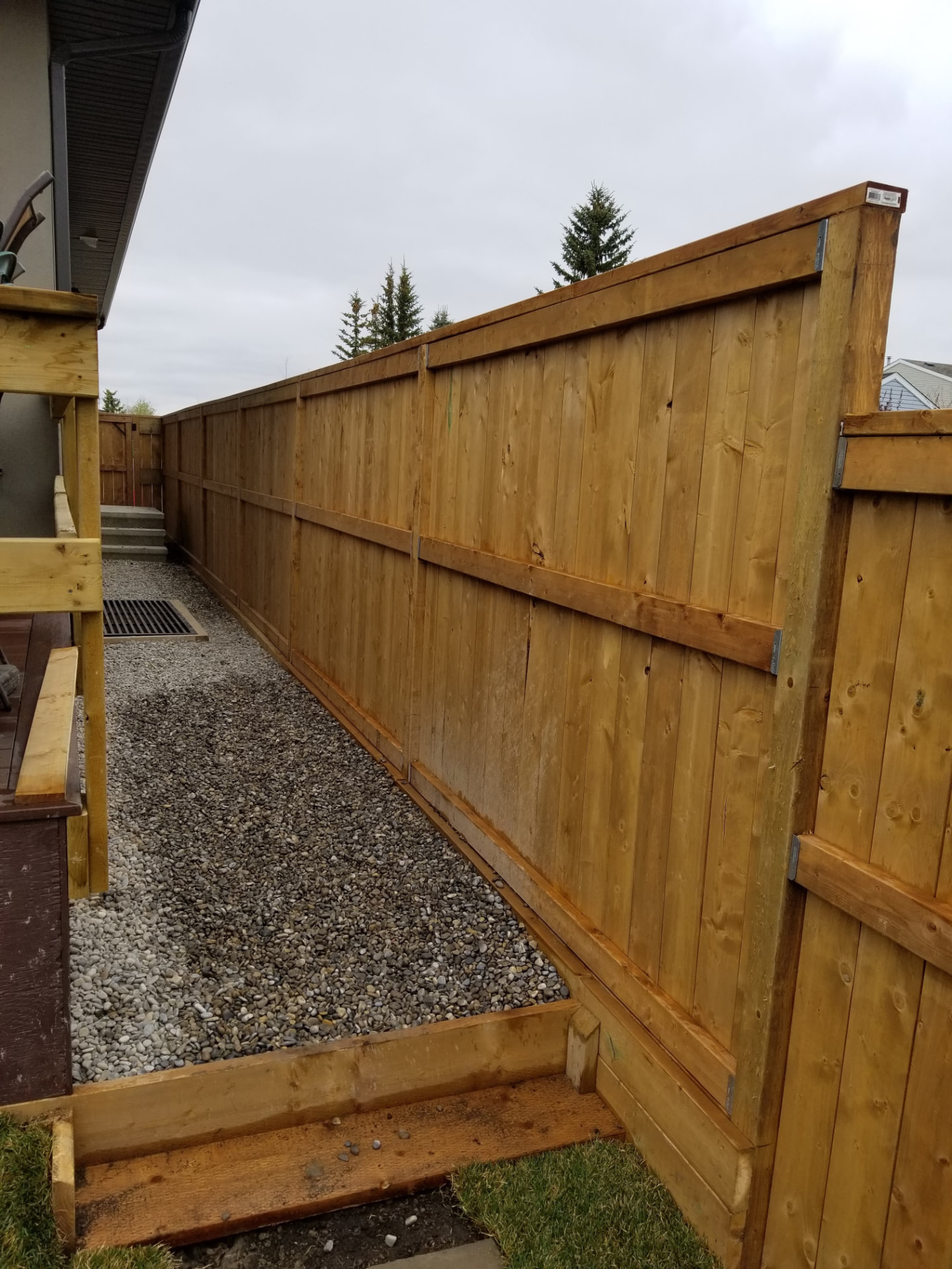 Cedar side-yard fence with rock drainage bed